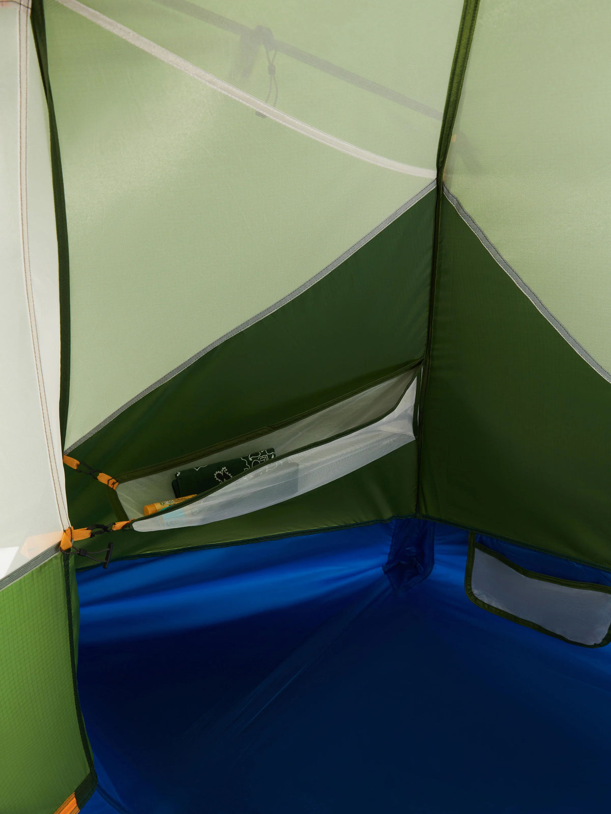 Close-up of a green and blue tent interior with a pocket.